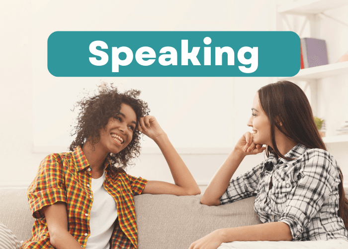 Two women are having a discussion in English together. They are wearing shirts with designs on them.